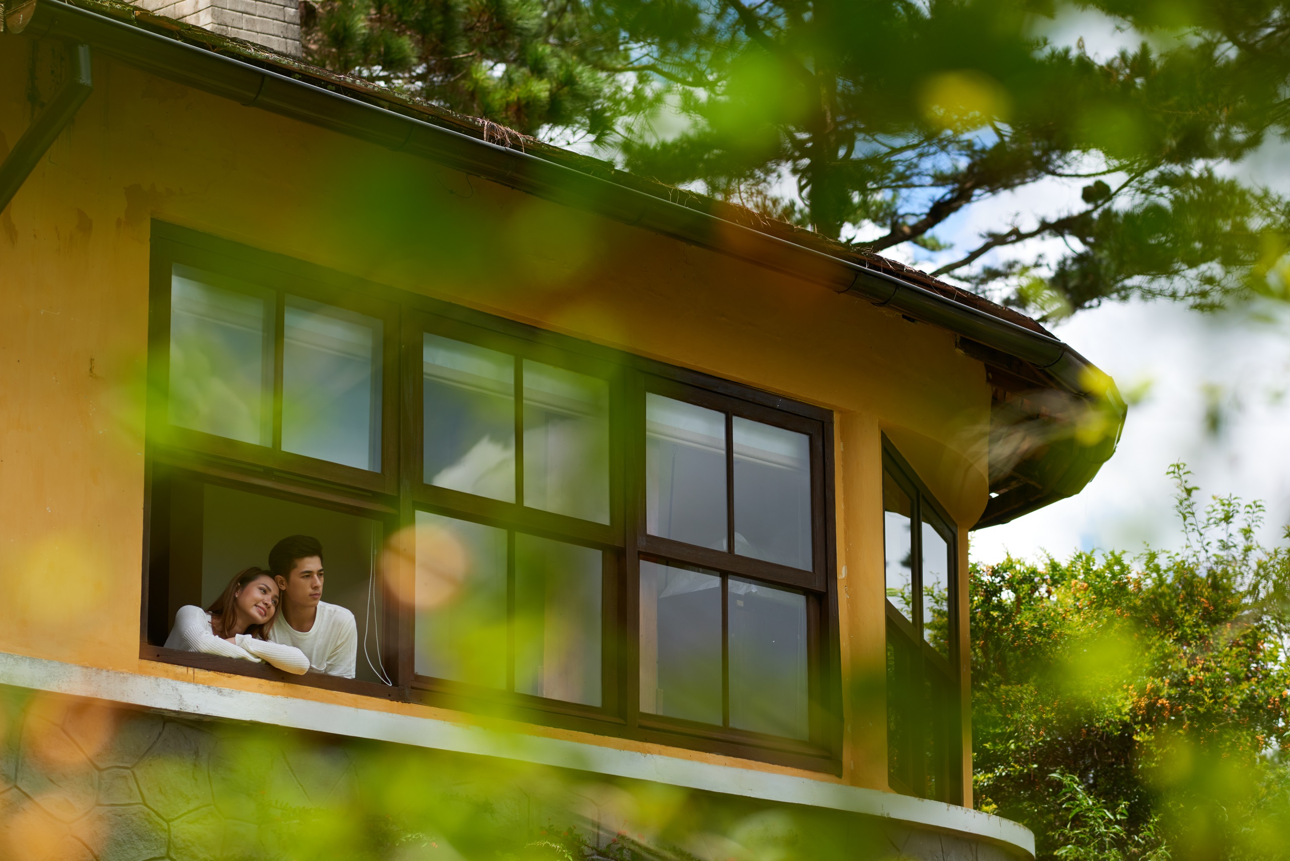 pareja mirando por la ventana casa familiar